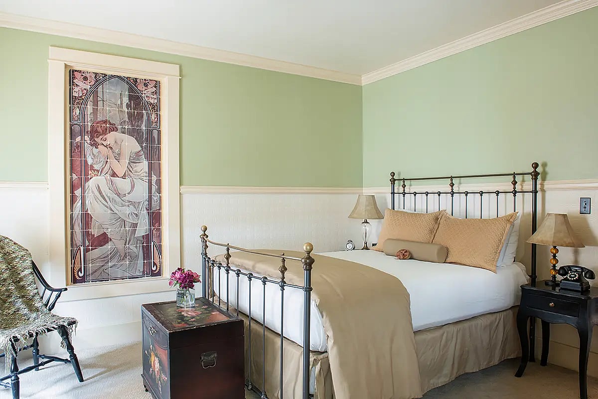 A beautiful antique iron bed awaits visitors at the end of the day on their best western adventure at the premier hotel in Cody, Wyoming, the Chamberlin Inn.
