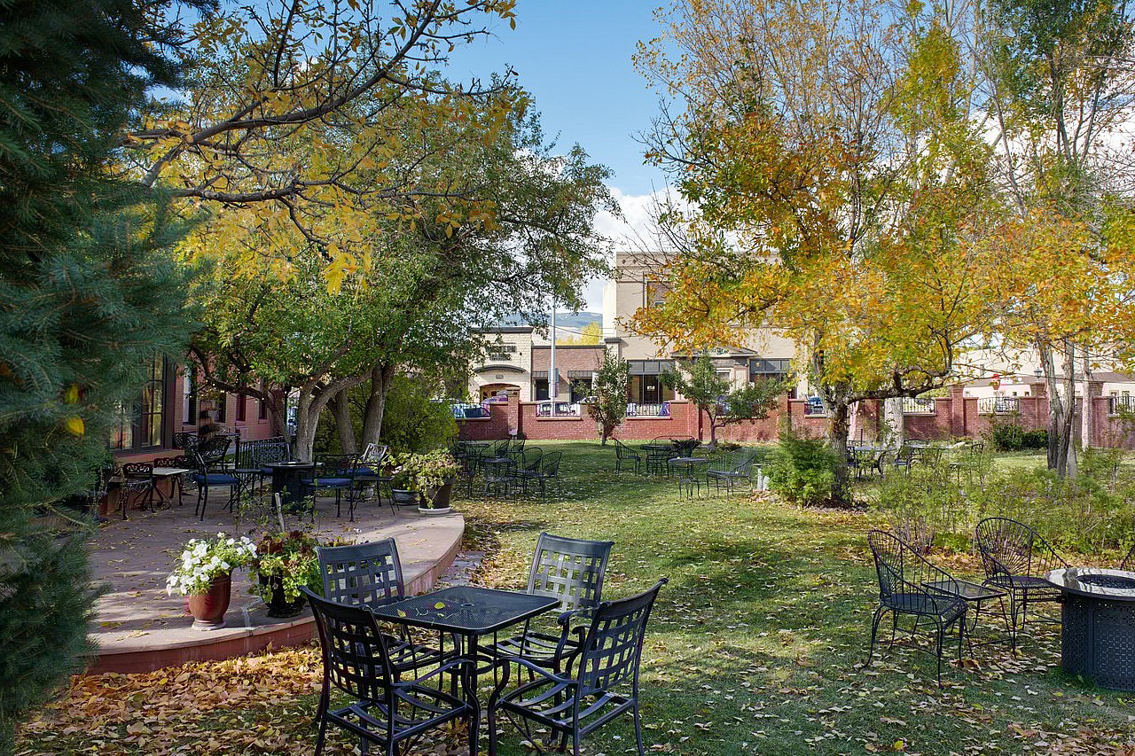 Outdoor seating in the relaxing courtyard at the Chamberlin Inn in Cody Wyoming - an exclusive, luxury hotel. thumbnail