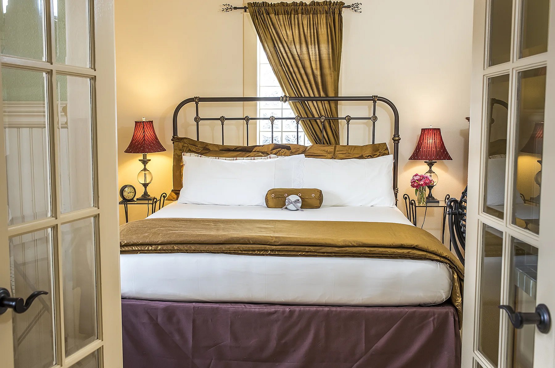 French doors open to the King bedroom suite at the Chamberlin Inn, a fancy historic hotel in the heart of downtown Cody, Wyoming. thumbnail