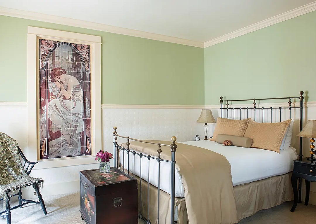 A beautiful antique iron bed awaits visitors at the end of the day on their best western adventure at the premier hotel in Cody, Wyoming, the Chamberlin Inn.