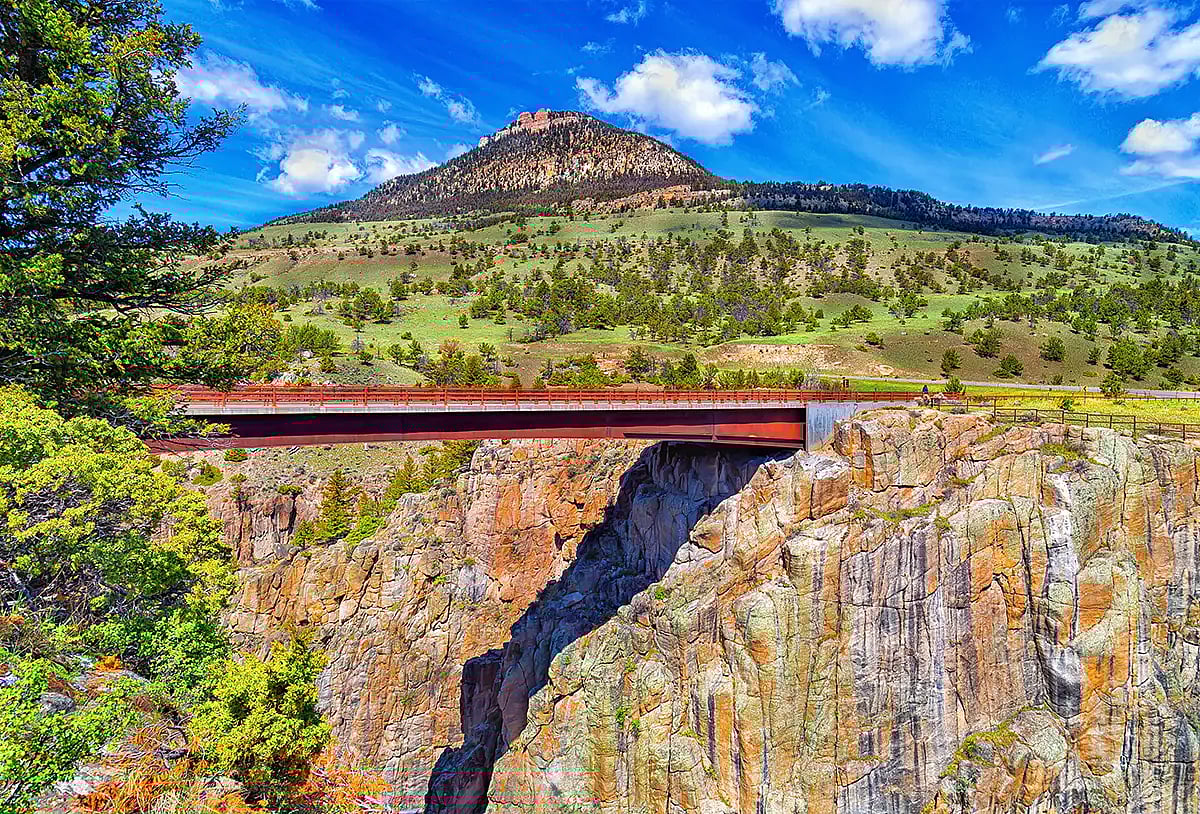 Picture of the bridge overlooking Chief Joseph scenic highway, part of a must-do day trip while staying in the Cody Wyoming area, knowing you will relax in comfort in the evening at the Chamberlin Inn.