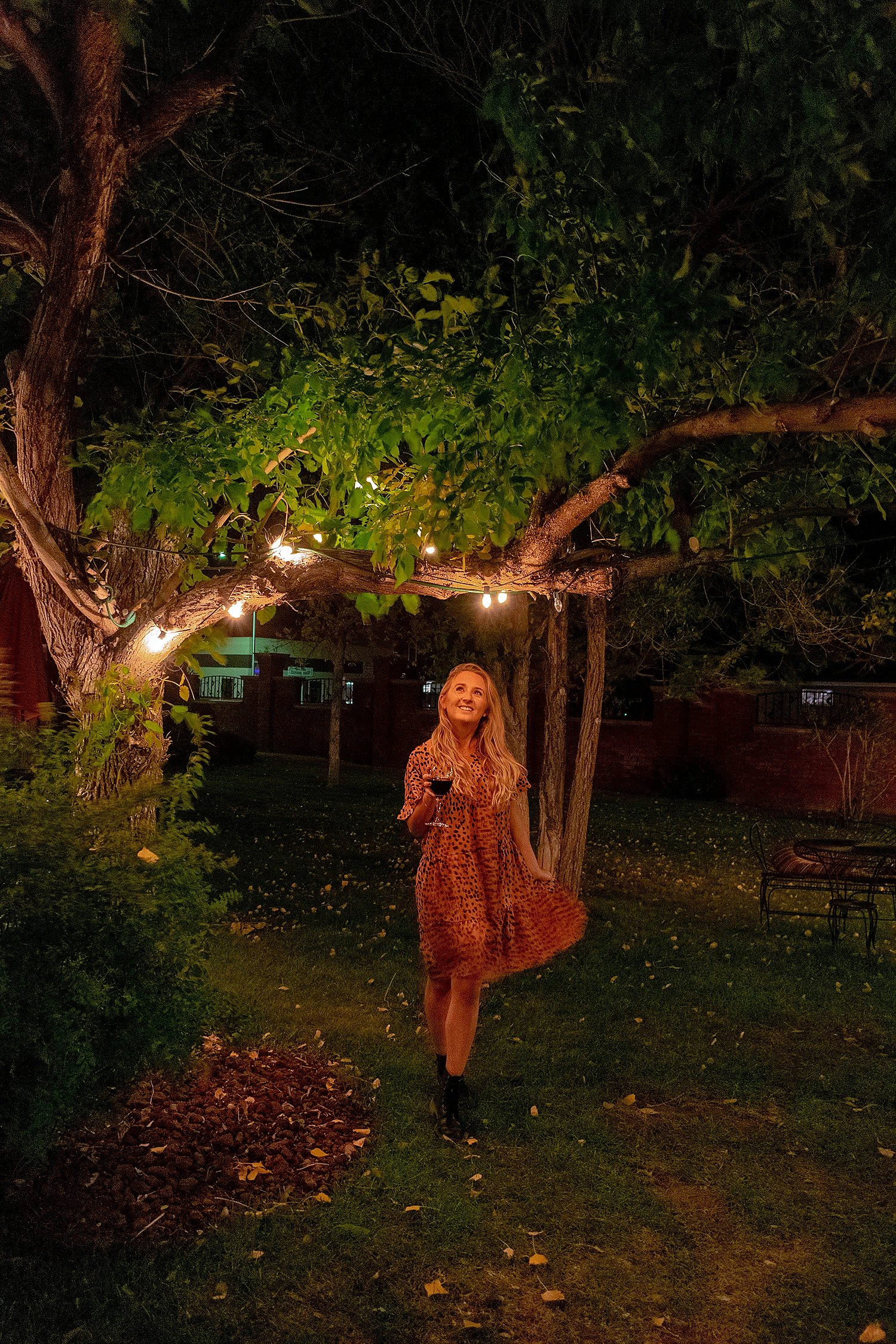 Taylor Deer walking under a tree at the Chamberlin with a glass of wine in her hand