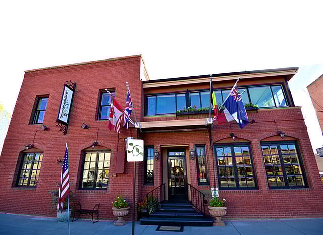The front entrance to the luxurious boutique hotel, the Chamberlin Inn in Cody, Wyoming. Many nations flags are flown at this hotel to honor the international travelers who come to vacation near Yellowstone in Cody, Wyoming.